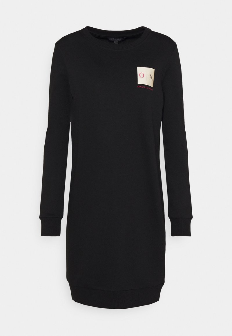 Robe sweat-shirt noire avec manches longues, poignets côtelés et col rond. Présente un patch carré avec des accents de texte sur la poitrine.