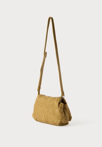 Bolsa de ombro amarela acolchoada com alça ajustável, apresentando padrões florais e uma textura suave. Forma retangular com fecho de aba.