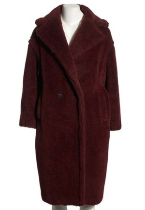 Long manteau teddy bordeaux foncé avec larges revers, un bouton visible et des poches latérales sur un mannequin blanc.