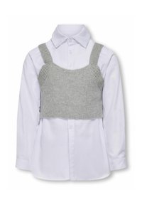 Grå strikket crop top over en hvid langærmet skjorte med knapper. Har stropper og ribbet tekstur på toppen. Knapp detalje på skjorten.