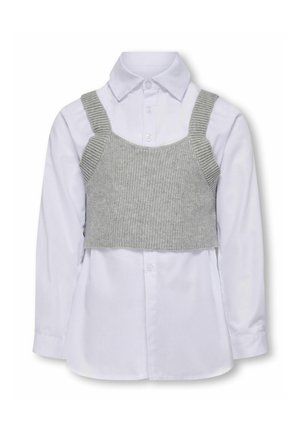 Grå strikket crop top over en hvid langærmet skjorte med knapper. Har stropper og ribbet tekstur på toppen. Knapp detalje på skjorten.