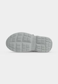 Semelle d'une chaussure grise avec un motif de bande de roulement texturé, marquage "superfit" et taille 26 visible en bas.