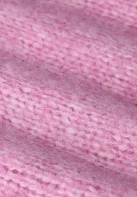 Tissu tricoté rose avec une texture douce et pelucheuse. Présente un tissage lâche et de légères variations de teinte, créant de la profondeur et un intérêt visuel.