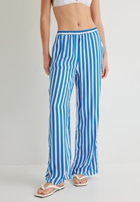 Blauwe en witte gestreepte broek met een elastische tailleband, gemaakt van lichte stof, met een losse pasvorm en wijde benen.