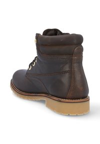 Botas de tobillo de cuero marrón con puntera redondeada, parte trasera texturizada y ojales dorados. Presenta un collar acolchado y una suela de goma.
