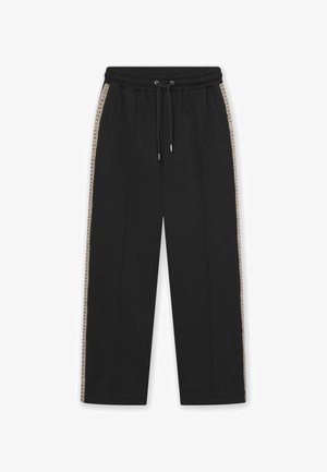 Svarte bukser laget av myk stoff, med snor i midjen, sidelommer og kontrastfargede beige dekorative striper langs sidene.