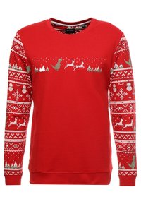 Punainen neulepaita, jossa on pitkät hihat. Edessä ja hihoissa juhlallinen kuvio, jossa on dinosauruksia, poroja ja lumihiutaleita vihreänä ja valkoisena.