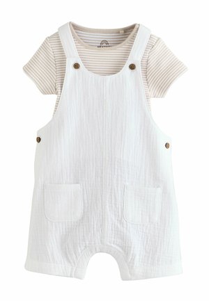 Weißer, strukturierter Baumwollstrampler mit Fronttaschen über einem beige-weiß gestreiften Kurzarmshirt für ein Baby oder Kleinkind.