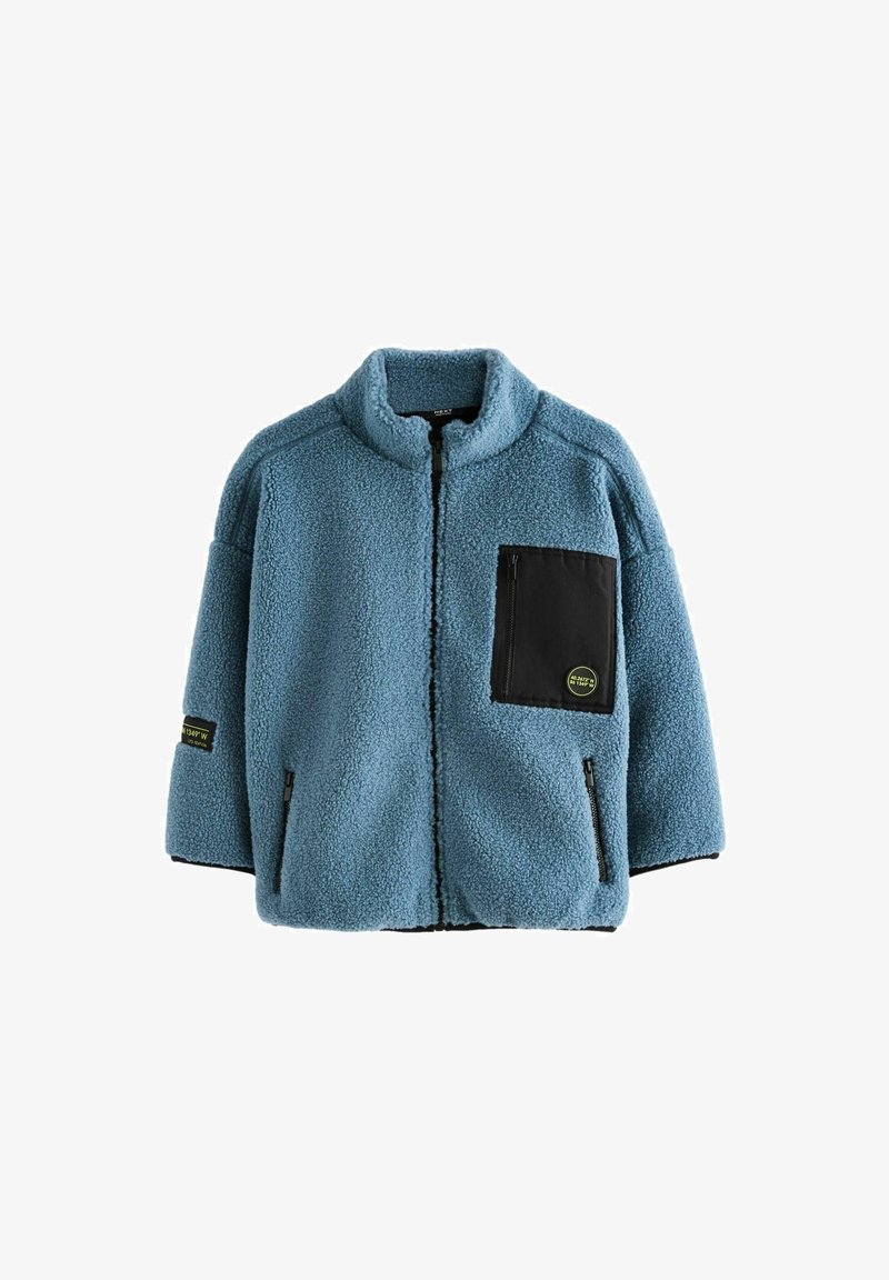 Blaue Fleecejacke mit hohem Kragen, schwarzem Reißverschlusstaschen und Seitentaschen. Ausgestattet mit einem strukturierten Stoff und kurzen Ärmeln.