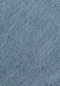 Tela de mezclilla en azul claro con una textura tejida, que presenta un patrón de espiga clásico y sutiles variaciones en el color para dar profundidad.
