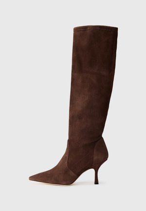 Brune suede over-the-knee støvle med spids tå og tynd hæl. Har en glat tekstur og sømløst design, der fremhæver elegante, slanke linjer.