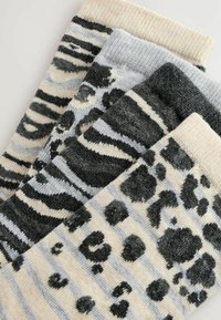 Četiri para anklet čarapa s uzorcima životinja: leopard, zebra i naizmjenične prugice u sivoj, bež i crnoj boji. Meka tekstura.