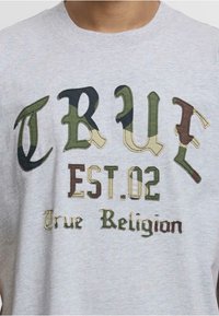 Szara bawełniana koszulka z multikolorowym haftem z napisami: "TRUE", "EST.02" oraz "True Religion" w różnych stylach czcionek i wzorach kamuflażu.