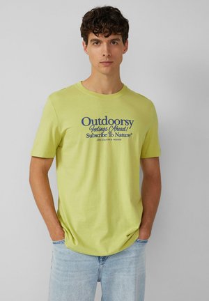 Hellgrünes Baumwoll-T-Shirt mit kurzen Ärmeln, auf dem blauer Text steht: "Draußen fühlst du dich gut! Abonniere die Natur®."