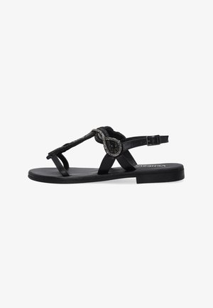 Zwarte platte sandalen met een teenpostontwerp, voorzien van een decoratieve metalen accent en een verstelbare enkelband. Zacht materiaal en een gestructureerde afwerking.