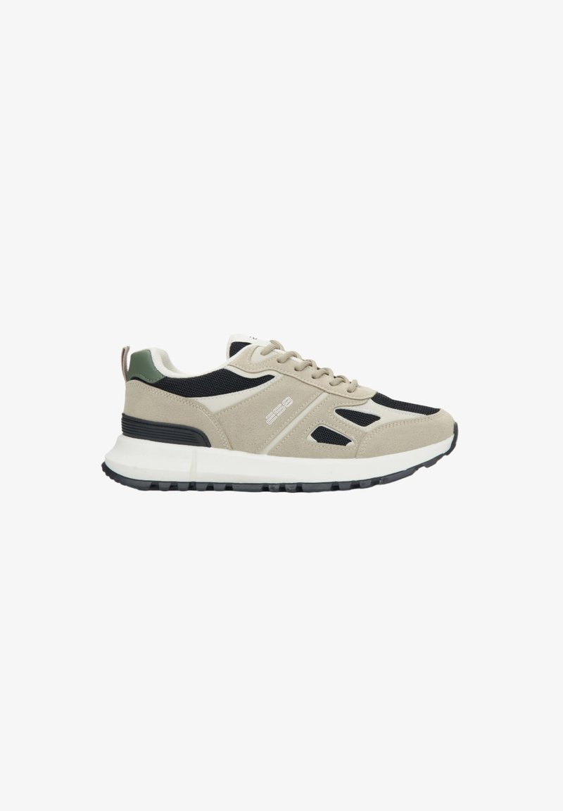 Beige und schwarze Sportschuh mit einem strukturierten Wildleder- und Mesh-Obermaterial, weißer Zwischensohle und einem grünen Akzent an der Ferse. Verfügt über eine Gummisohle.