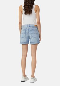 Lichtblauwe denimshorts met opgerolde mouwen, achterzakken met afgeronde stiksels en een bruine leren patch bij de taille.