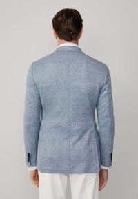 Helleblaue strukturierte Jacke im Slim-Fit-Schnitt, mit einem Schlitz hinten und Manschetten mit drei Knöpfen. Hergestellt aus gewebtem Stoff, mit einem Revers.