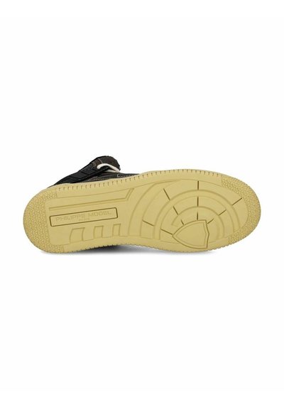 Sneaker nera con tomaia in pelle testurizzata, suola in gomma beige con battistrada strutturato e marchio impresso sulla suola.