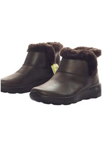 Braune Lederstiefeletten mit einem weichen, braunen Fellbesatz. Sie verfügen über eine abgerundete Zehenpartie und eine dicke, strukturierte Sohle für Komfort und Unterstützung.