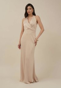 Garšs, piegulošs halter stila kleita maiga beige audumā, ar ietītu topu, elegantu drapējumu un gludu, plūstošu siluetu.