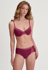 Bordeaux lingerieset met een gevormde beha met verstelbare bandjes en bijpassende high-waisted slips, beiden van een gladde, rekbare stof.