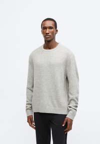 Ανοιχτό γκρι πουλόβερ από μαλακό ύφασμα, με στρογγυλή λαιμόκοψη και μακρυά μανίκια, σε άνετη εφαρμογή και με ριπ φινίρισμα στο τελείωμα.