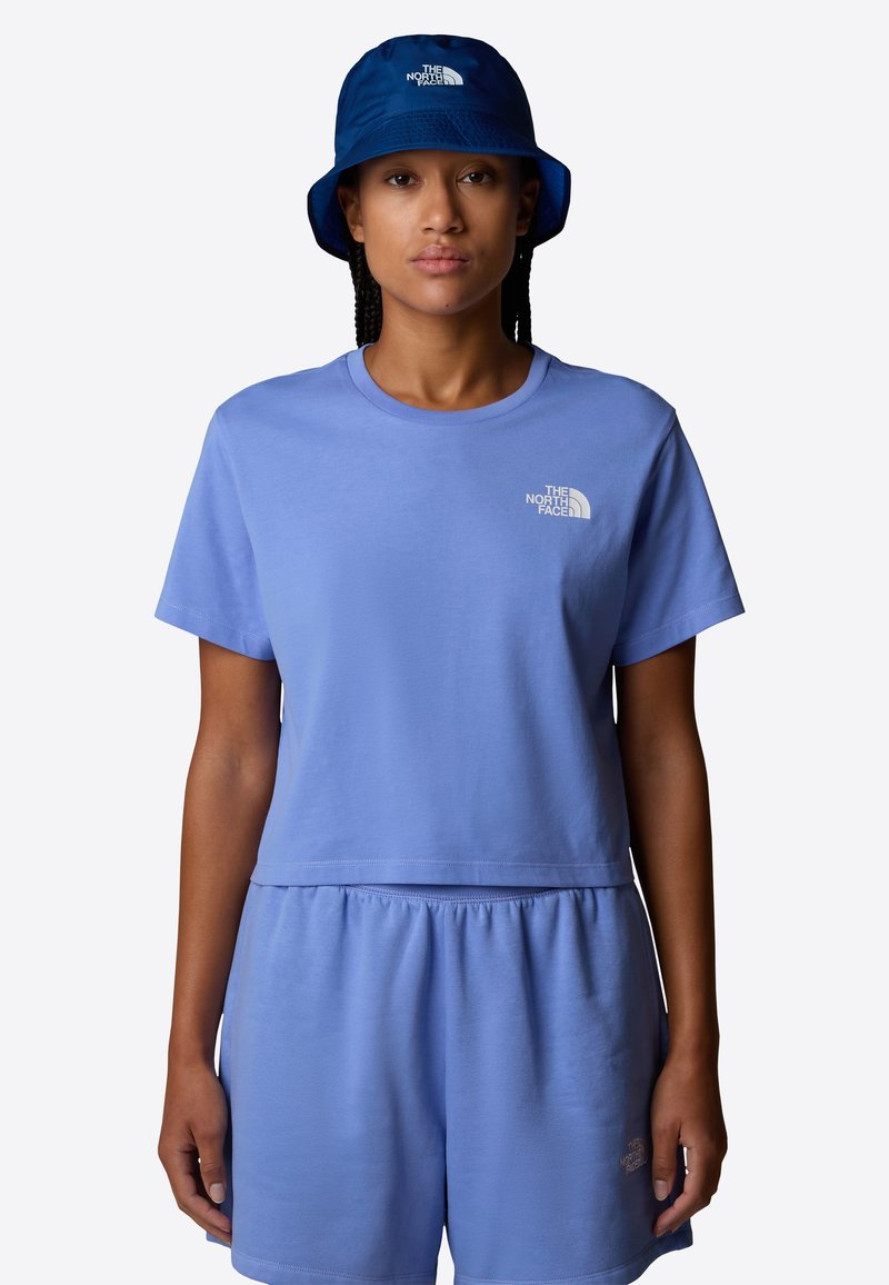 T-shirt in cotone azzurro chiaro e pantaloni corti abbinati con vita elastica. Cappellino a secchiello blu con logo bianco. Tessuto morbido, design casual.