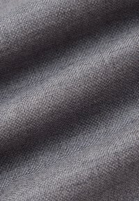 Szary teksturowany materiał z tkanym wzorem, ukazujący miękkie, lekko pomarszczone fałdy. Materiał wydaje się trwały i wszechstronny, odpowiedni do różnych zastosowań.