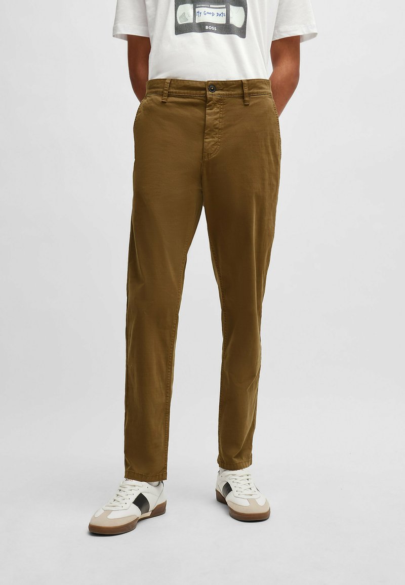 Pantalons en coton marron à coupe droite, avec deux poches avant et une fermeture par un bouton à la taille. Détails de couture soignés.