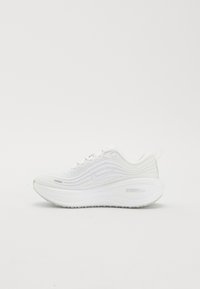 Chaussure de course blanche avec tige texturée, logo Nike swoosh, semelle épaisse et coussinée, et languette au talon.