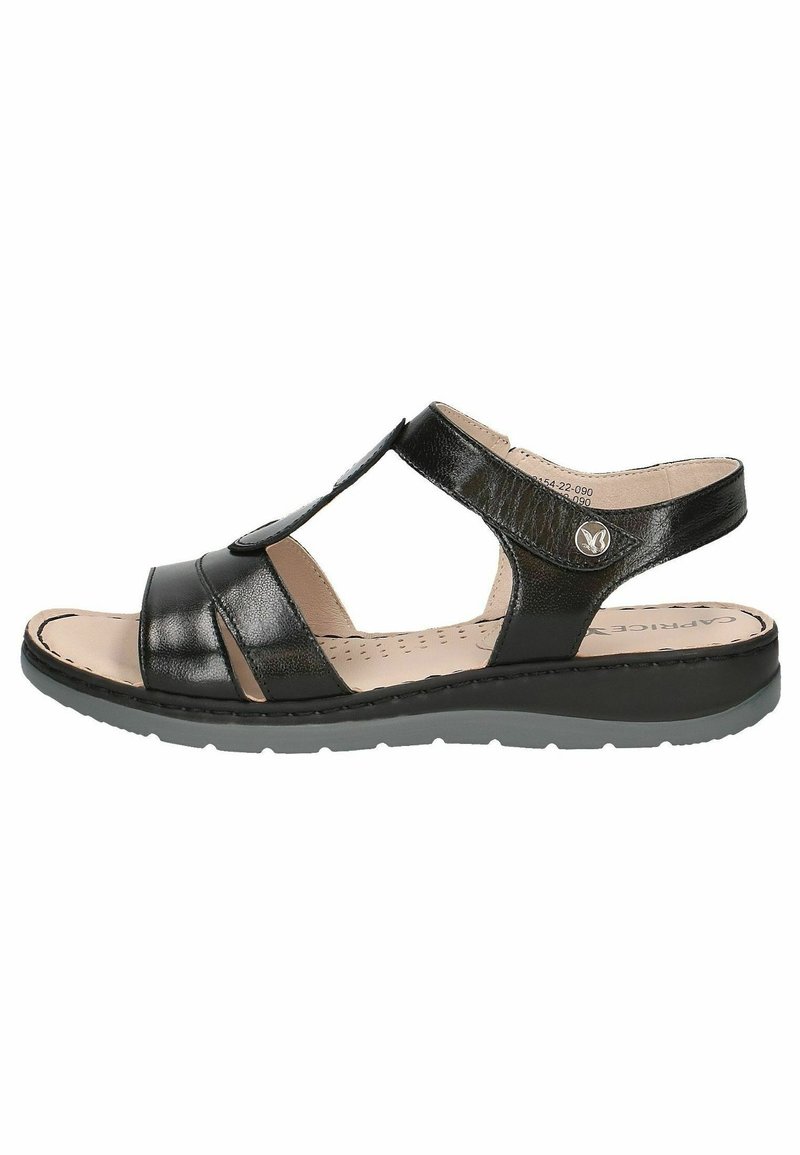 Sandale ouverte noire en cuir avec des sangles réglables, semelle intérieure beige rembourrée et semelle en caoutchouc conçue pour le confort et un port décontracté.