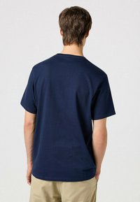 Marineblå bomulds t-shirt med korte ærmer, rund hals og lige kant. Ingen synlige mønstre eller logoer på bagsiden.