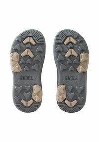 Suole delle scarpe in gomma grigia con un motivo di impugnatura testurizzata. Presenta accenti marrone chiaro in varie forme triangolari e il nome del marchio "reima."