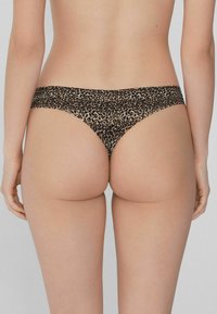 Bikini w leopardzim wzorze, miękka tkanina, niskie biodra, gładka faktura, minimalna osłona i szeroki pas. 