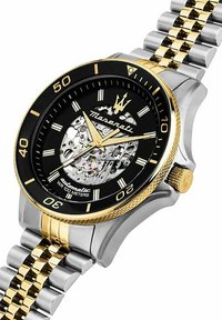 Maserati Automatikuhr mit schwarzem Zifferblatt, goldenen Akzenten, einem Armband aus Edelstahl und Gold sowie einem transparenten Gehäuseboden, der die inneren Mechanismen offenbart.