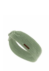 Fascia in maglia di un verde chiaro, con design attorcigliato. Include un piccolo etichetta marrone con il nome del marchio. Texture morbida, vestibilità elastica.