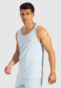 Lichtblauw tanktop van katoen, met een ronde halslijn, brede armsgaten en een klein zilveren logo detail aan de voorkant.