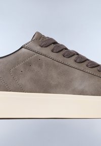 Scarpa con una tomaia in suede marrone chiaro, dotata di punta arrotondata, lacci piatti e una suola in gomma color crema con dettagli di cucitura minimi.