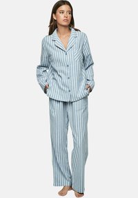 Lichtblauwe gestreepte pyjama-set gemaakt van zachte stof; beschikt over een knoopsluiting bovenkant met een zak en bijpassende losse broek.