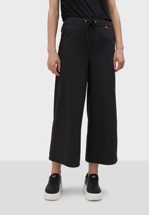 Black wide-leg trousers with an elastic waistband, drawstring tie, and side pockets. Lightweight fabric with a smooth texture.