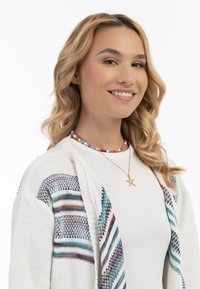 Bunte Perlenkette mit einem Seesternanhänger an einem Model. Das Model trägt einen weißen Strickpullover mit bunt gestreiften Mustern.
