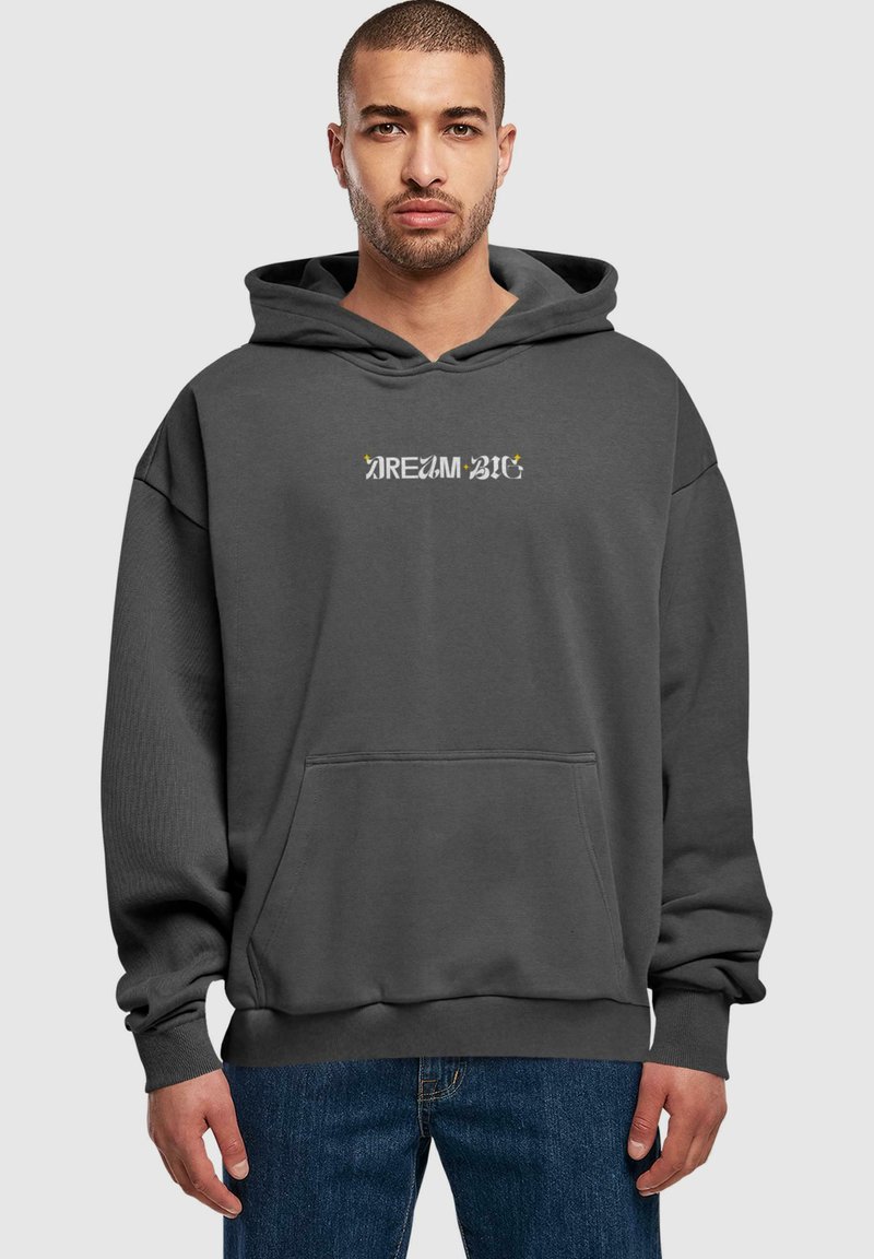 Szürke kapucnis pulóver, elől zsebes, oversize fazonban, kontrasztos színkombinációval megjelenő "DREAM BIG" felirattal. Puha szövettextúra.