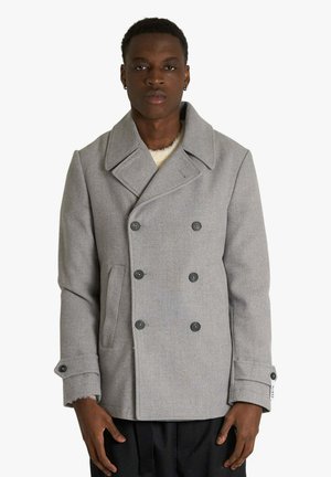 Cappotto di lana grigio con design doppiopetto, grandi revers e quattro bottoni scuri. Presenta tasche frontali e dettagli sui polsini.