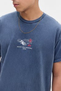 Blå bomulds t-shirt med korte ærmer, der har et grafisk tryk af bjerge og teksten "MOUNT HAKU, NISHIWAKI, JAPAN" i rød og hvid.