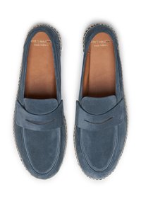 Mocasines de ante azul con un diseño cosido, plantilla de cuero y suela beige en contraste. Presentan una barra decorativa en la parte superior.