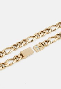 Collier en chaîne dorée avec des maillons entrelacés, une finition lisse et un fermoir rectangulaire avec un logo en relief.