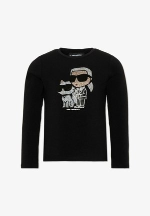 Camiseta negra de manga larga con figuras de dibujos animados de un hombre con gafas de sol y un perro hechas con pedrería, con el texto "KARL LAGERFELD" debajo.