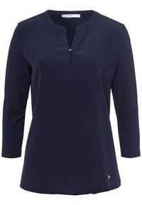 Haut à manches longues bleu marine avec un décolleté fendu, doté d'un bouton décoratif au niveau de la patte de boutonnage et d'un petit logo accentué sur l'ourlet.