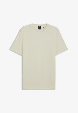 Beżowa, krótko rękawowa koszulka typu crew neck z czarną metką "BOSS" wewnątrz kołnierza, leżąca płasko na białym tle.